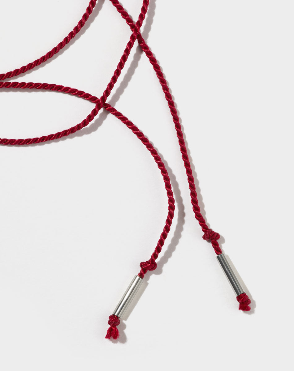 A red silk string necklace with silver ends.