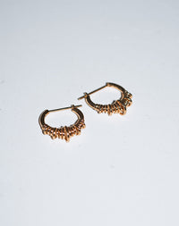 A pair of small hoop earrings made of sterling silver, with a series of rings suspended on a hoop.