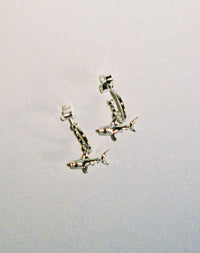 Sterling silver hoop earrings with shark charms attached.