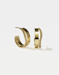A pair of gold hoop earrings with a pave of diamonds set on the hoops.