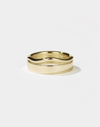 A gold ring with a flat, minimalist band and an organic, curvy rounded band, appearing as one sleek form.