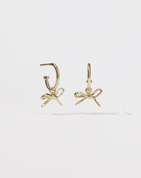 Gold hoop earrings with a small bow charms
