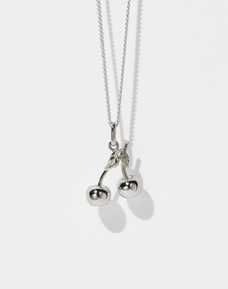 A sterling silver necklace featuring a cherry-shaped pendant on a fine chain.
