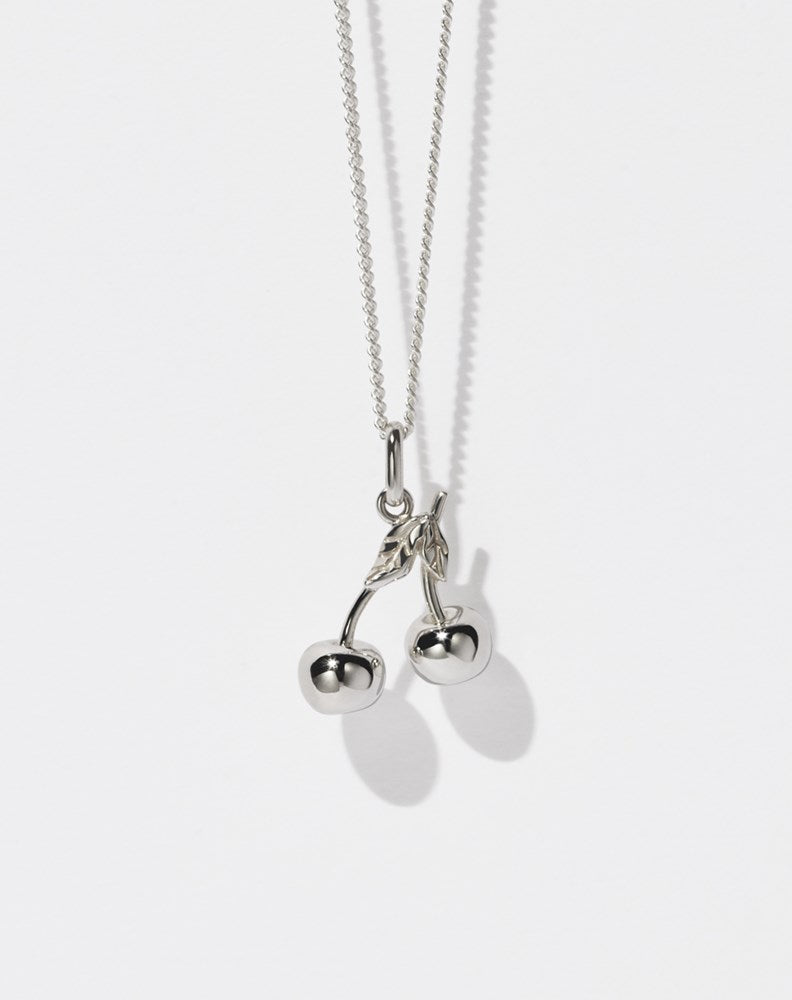 A sterling silver necklace featuring a cherry-shaped pendant on a fine chain.