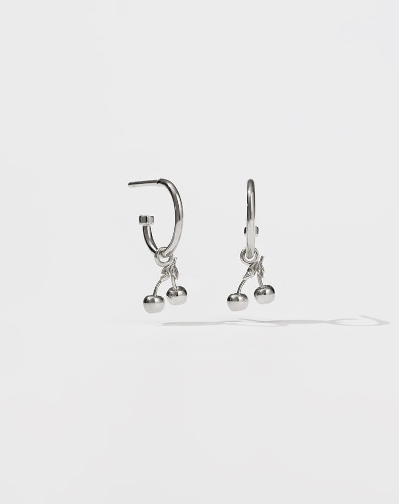 A pair of sterling silver hoop earrings with cherry charms attached