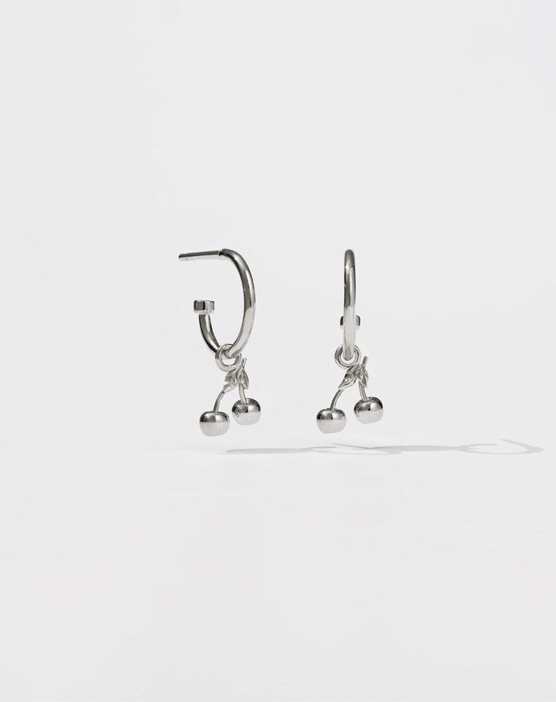 A pair of sterling silver hoop earrings with cherry charms attached