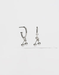 A pair of sterling silver hoop earrings with cherry charms attached