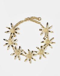 A gold-plated bracelet featuring a chain link with seven daisy flower designs
