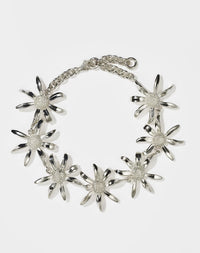 A sterling silver bracelet featuring a chain link design with seven daisy flower motifs