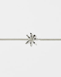 A sterling silver daisy charm bracelet with a classic curb chain design, featuring a single daisy charm centered on the bracelet.