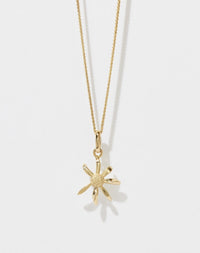 A gold daisy charm necklace on a fine chain