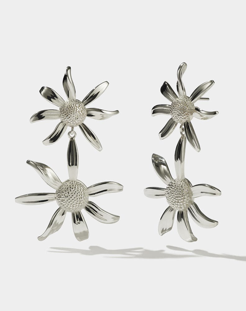 A pair of sterling silver drop earrings, featuring a stud back flower design with a larger flower dangling below.