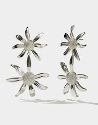 A pair of sterling silver drop earrings, featuring a stud back flower design with a larger flower dangling below.