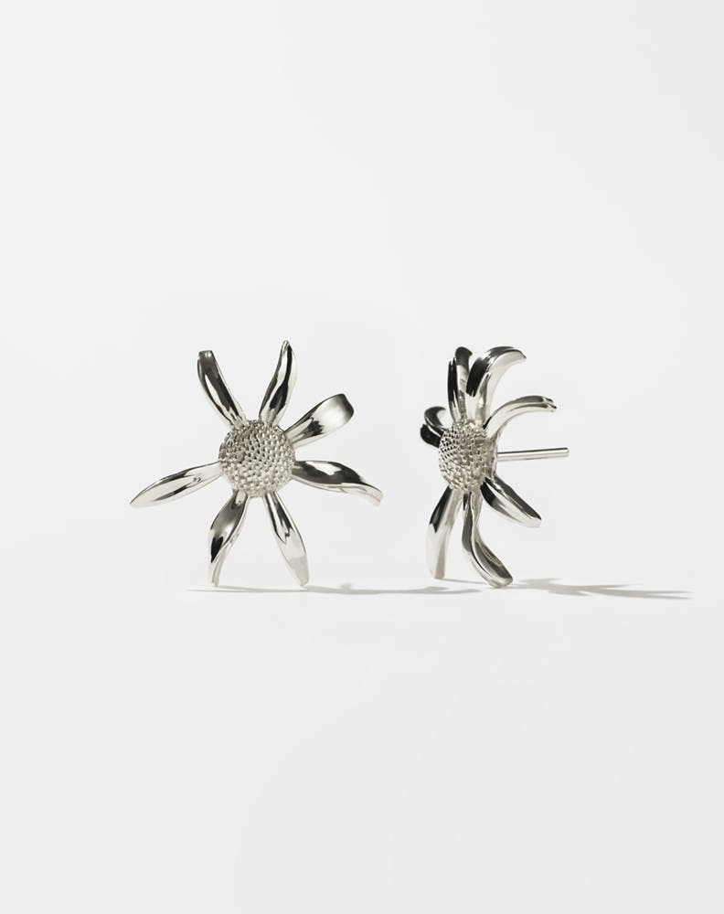 A pair of sterling silver daisy earrings with a bold stud design.
