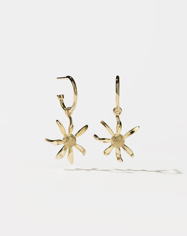 A pair of gold-plated hoop earrings with daisy charms attached