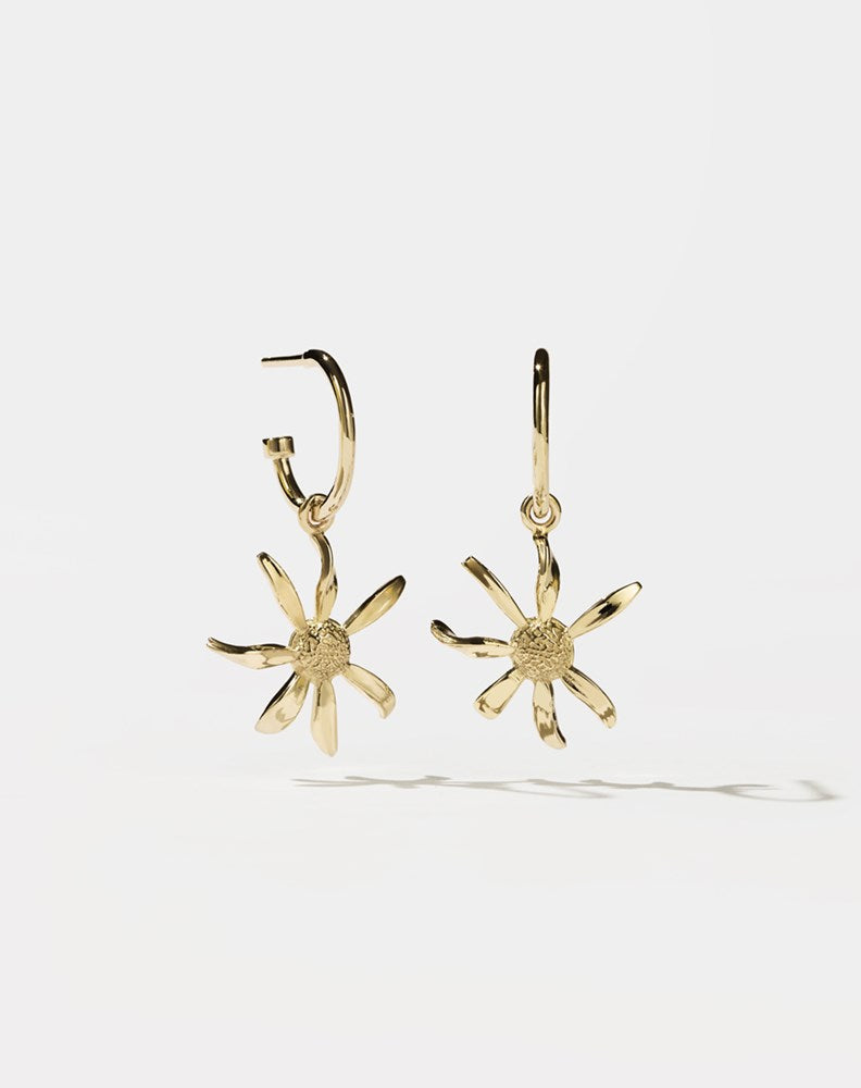 A pair of gold-plated hoop earrings with daisy charms attached