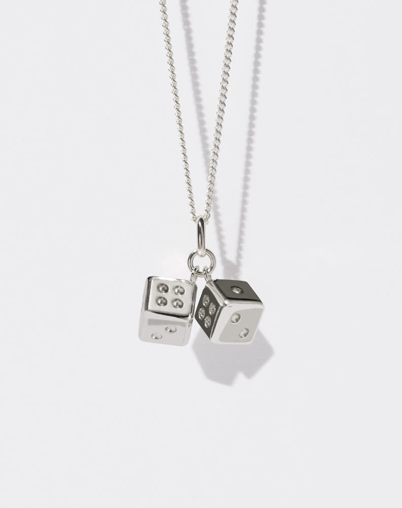 A sterling silver necklace featuring two dice charms attached to a fine chain.