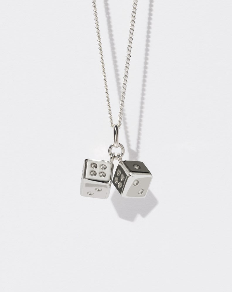 A sterling silver necklace featuring two dice charms attached to a fine chain.