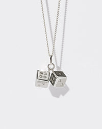 A sterling silver necklace featuring two dice charms attached to a fine chain.