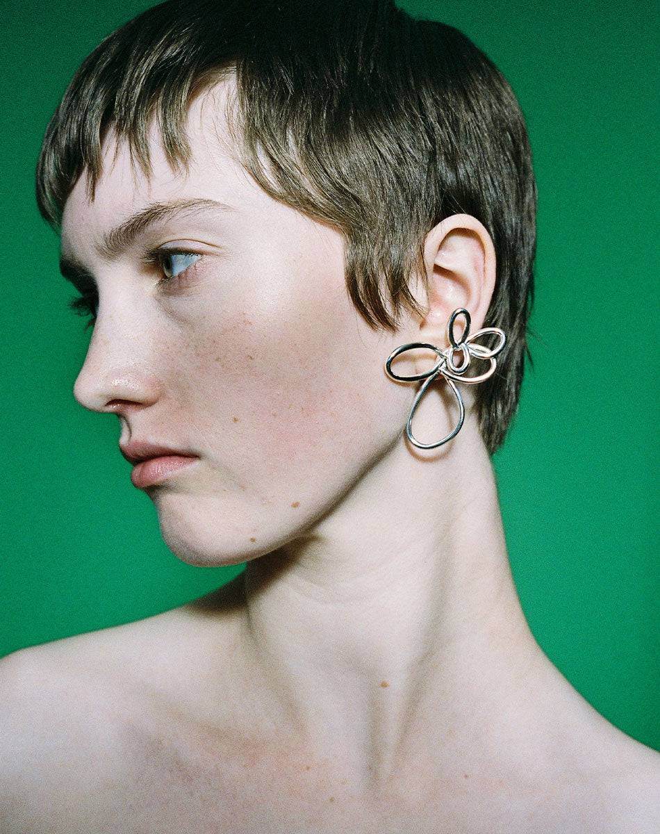 Silver flower earrings in two sizes worn by model