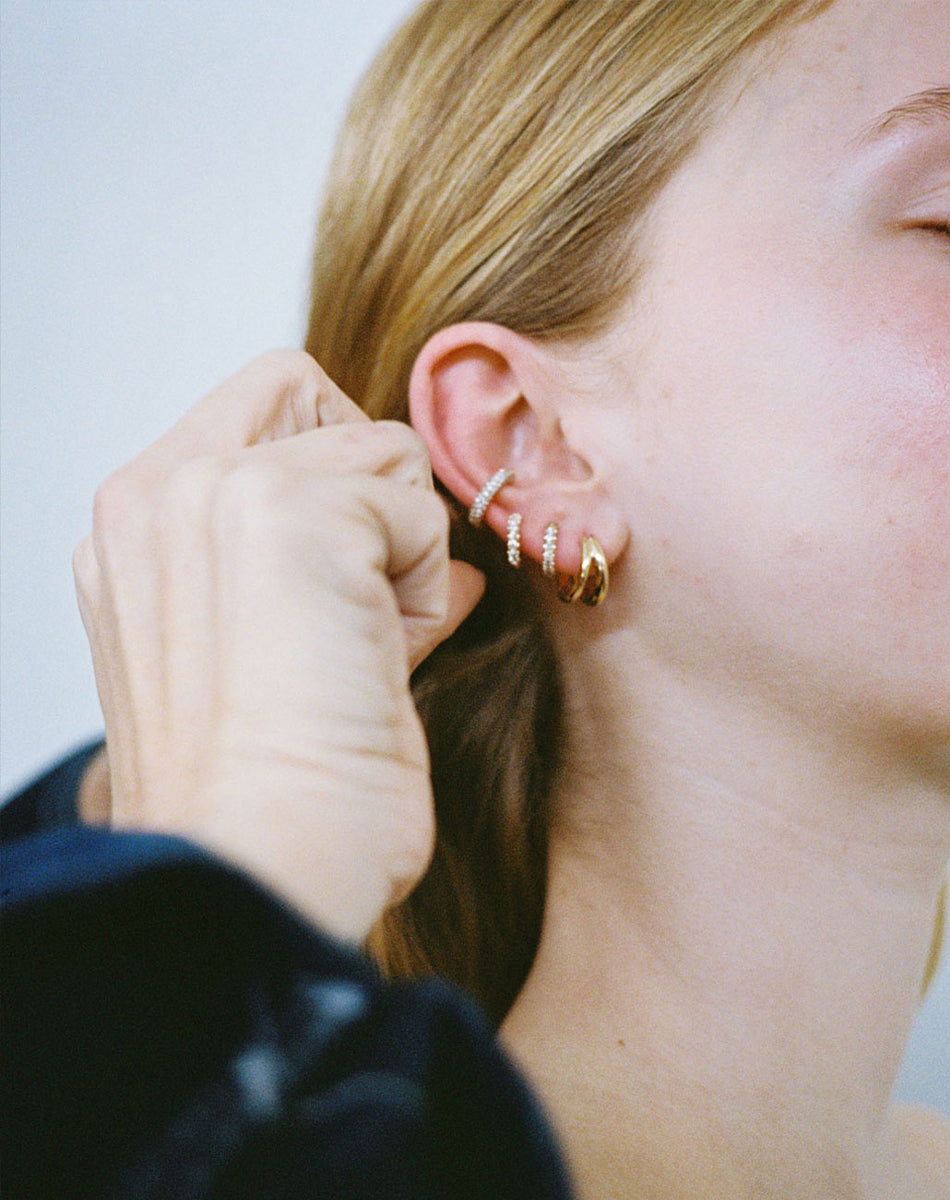 Meadowlark Jewllery's Halo Ear Cuff Triple Pave Small, Halo Huggies Pave, Coco Hoop Earrings Medium in 9ct Yellow Gold with round brilliant cut white diamonds. Worn stacked on model ear.