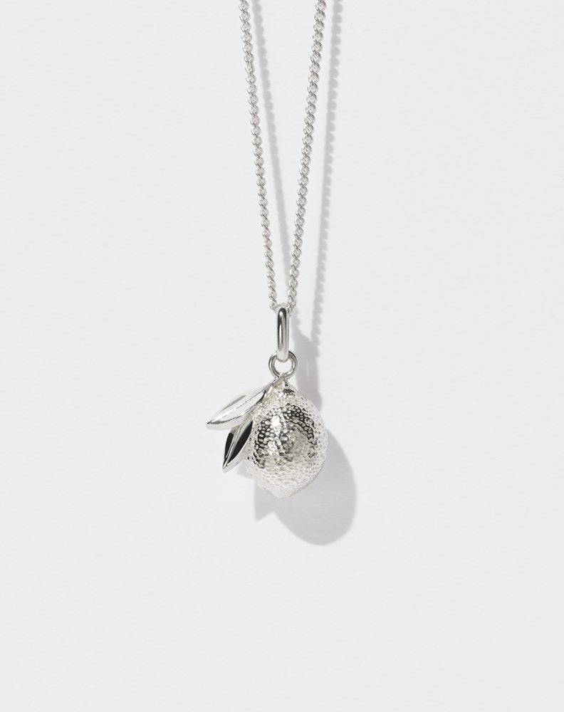 A sterling silver necklace with a lemon charm, suspended from a fine chain.