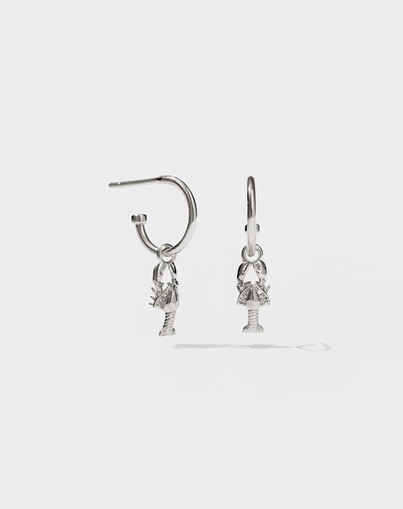 A pair of sterling silver hoop earrings with lobster charms attached