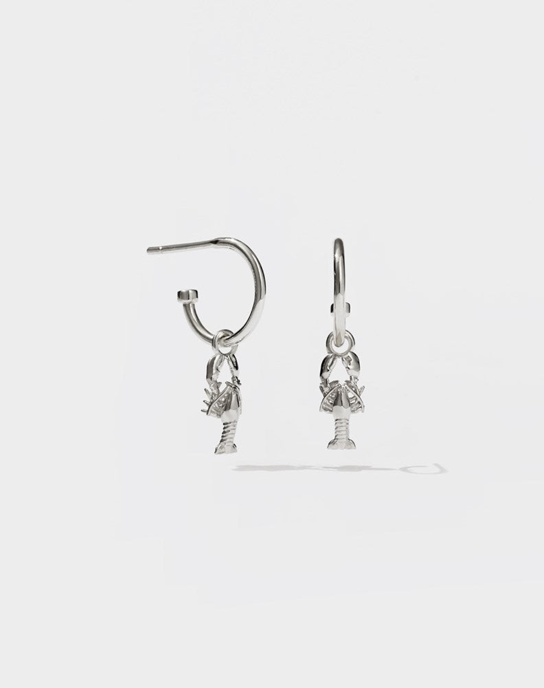 A pair of sterling silver hoop earrings with lobster charms attached