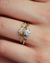 Floral Diamond Engagement Ring with matching band, on a hand.