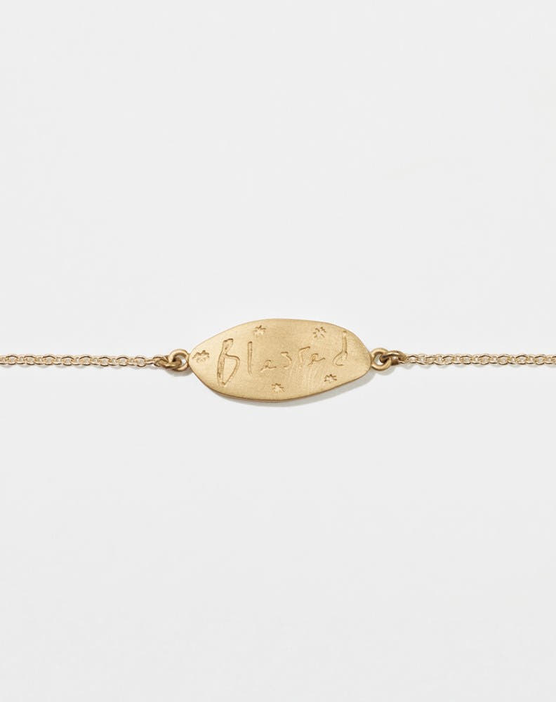 Meadowlark Jewellery’s Blessed Bracelet in 9ct Yellow Gold. A meaningful talisman for life’s journey, to serve as a daily reminder to honour the present and embrace gratitude for the quiet abundance all around us. A classic name tag in a matte, brushed texture inspired by ancient heirlooms hung from a fine diamond curb chain.  From the Dreams collection.