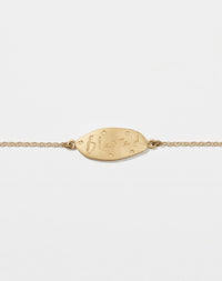 Meadowlark Jewellery’s Blessed Bracelet in 9ct Yellow Gold. A meaningful talisman for life’s journey, to serve as a daily reminder to honour the present and embrace gratitude for the quiet abundance all around us. A classic name tag in a matte, brushed texture inspired by ancient heirlooms hung from a fine diamond curb chain.  From the Dreams collection.