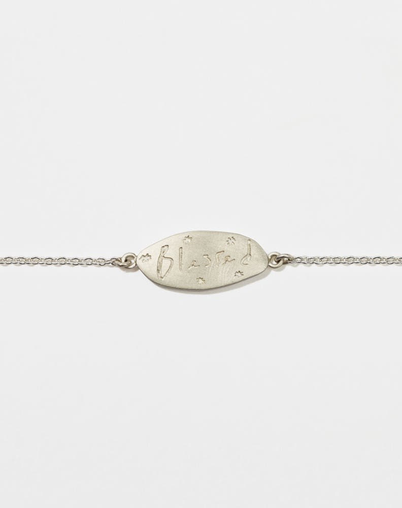 Meadowlark Jewellery’s Blessed Bracelet in Sterling Silver. A meaningful talisman for life’s journey, to serve as a daily reminder to honour the present and embrace gratitude for the quiet abundance all around us. A classic name tag in a matte, brushed texture inspired by ancient heirlooms hung from a fine diamond curb chain. From the Dreams collection.