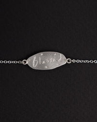 Meadowlark Jewellery’s Blessed Bracelet in Sterling Silver. A meaningful talisman for life’s journey, to serve as a daily reminder to honour the present and embrace gratitude for the quiet abundance all around us. A classic name tag in a matte, brushed texture inspired by ancient heirlooms hung from a fine diamond curb chain. From the Dreams collection.