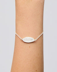 Meadowlark Jewellery’s Blessed Bracelet in Sterling Silver. A meaningful talisman for life’s journey, to serve as a daily reminder to honour the present and embrace gratitude for the quiet abundance all around us. A classic name tag in a matte, brushed texture inspired by ancient heirlooms hung from a fine diamond curb chain. From the Dreams collection. From the Dreams collection.