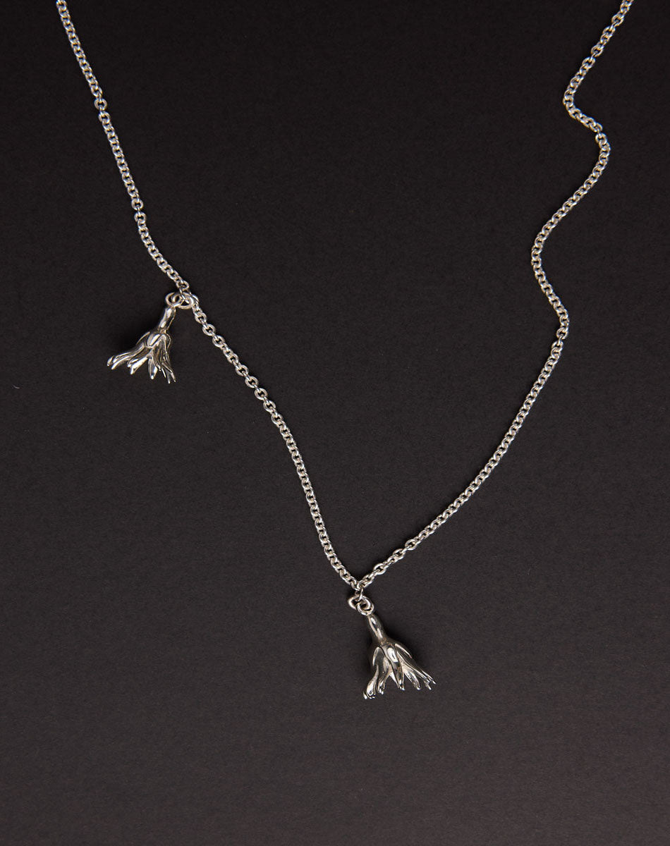 Meadowlark Jewellery’s Magda Two Charm Necklace in Sterling Silver. Two delicate, bell-shaped flower charms suspended from a fine diamond curb chain. A minimalist ode to blooming and the enduring cycles of life. From the Dreams collection.