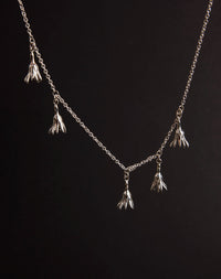 Meadowlark Jewellery’s Magda Five Charm Necklace in Sterling Silver. Five delicate, bell-shaped flower charms suspended from a fine diamond curb chain. A poetic celebration of growth, transformation, and the eternal rhythm of nature. A statement of quiet strength and beauty. From the Dreams collection.