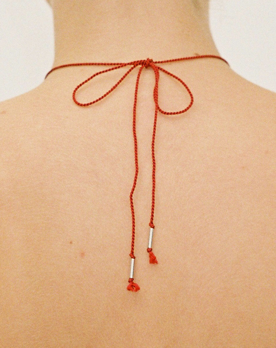 Meadowlark Jewellery’s Magda String Necklace in Sterling Silver. A single bell-shaped flower charm suspended from a vibrant red silk string. A striking and unconventional piece that can be styled at any length, from choker to torso. From the Dreams collection.