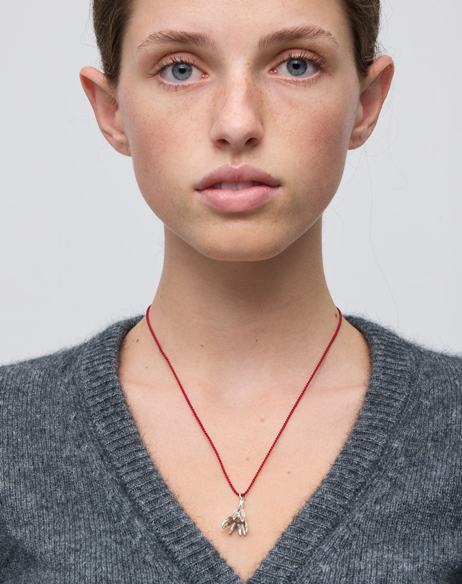 Meadowlark Jewellery’s Magda String Necklace in Sterling Silver. A single bell-shaped flower charm suspended from a vibrant red silk string. A striking and unconventional piece that can be styled at any length, from choker to torso. From the Dreams collection.
