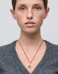 Meadowlark Jewellery’s Magda String Necklace in Sterling Silver. A single bell-shaped flower charm suspended from a vibrant red silk string. A striking and unconventional piece that can be styled at any length, from choker to torso. From the Dreams collection.