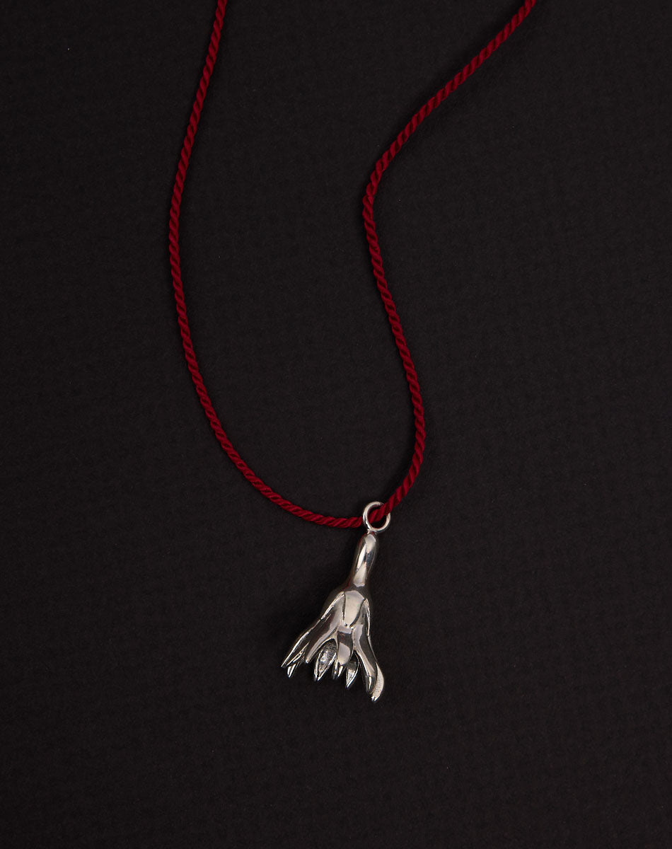 Meadowlark Jewellery’s Magda String Necklace in Sterling Silver. A single bell-shaped flower charm suspended from a vibrant red silk string. A striking and unconventional piece that can be styled at any length, from choker to torso. From the Dreams collection.