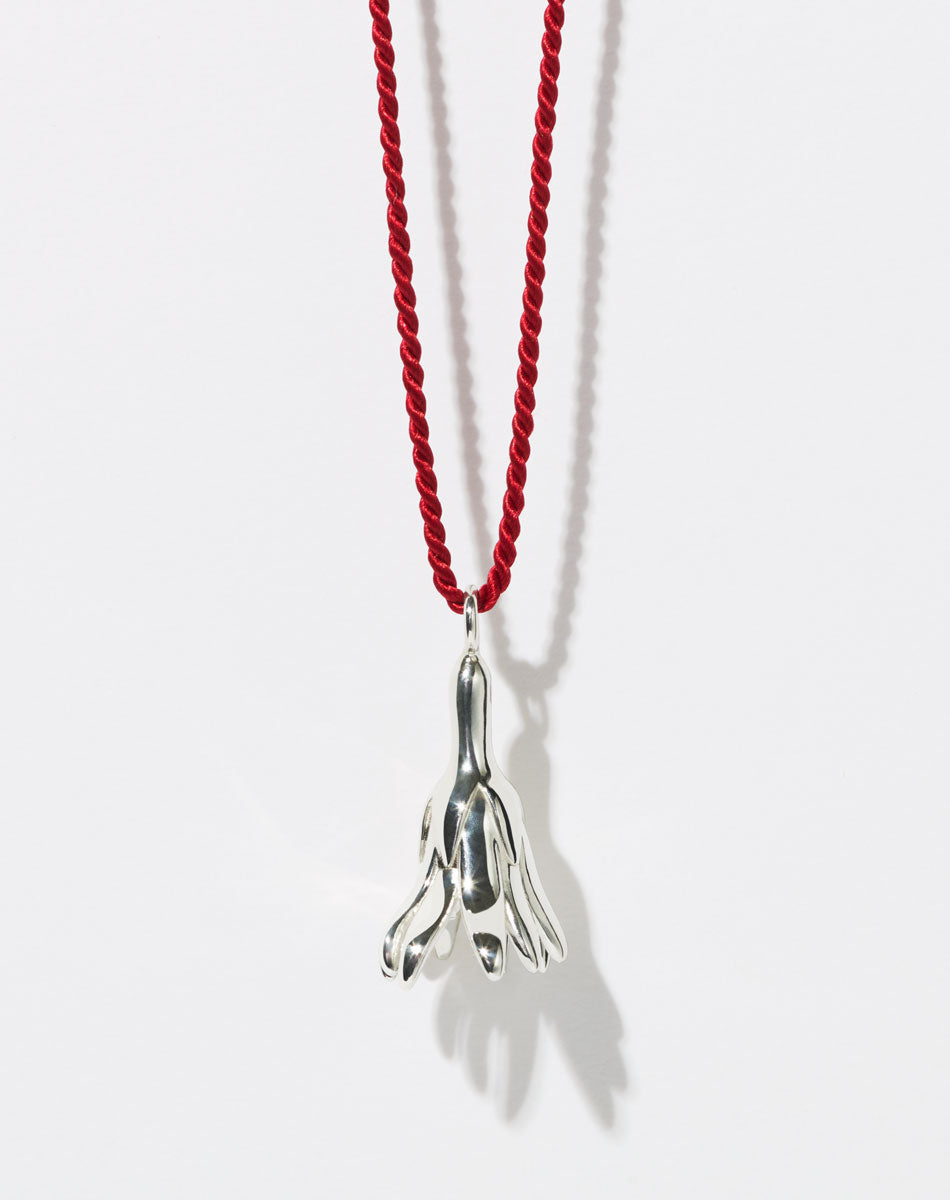 Meadowlark Jewellery’s Magda String Necklace in Sterling Silver. A single bell-shaped flower charm suspended from a vibrant red silk string. A striking and unconventional piece that can be styled at any length, from choker to torso. From the Dreams collection.