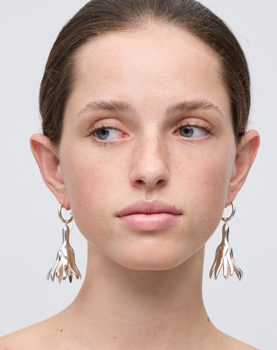 Meadowlark Jewellery’s sculptural Magda Drop Earrings Large in Sterling Silver. Bell-shaped flowers suspended from our classic Aria Hoop Earrings. A bold, deliberately off-beat statement. From the Dreams collection.