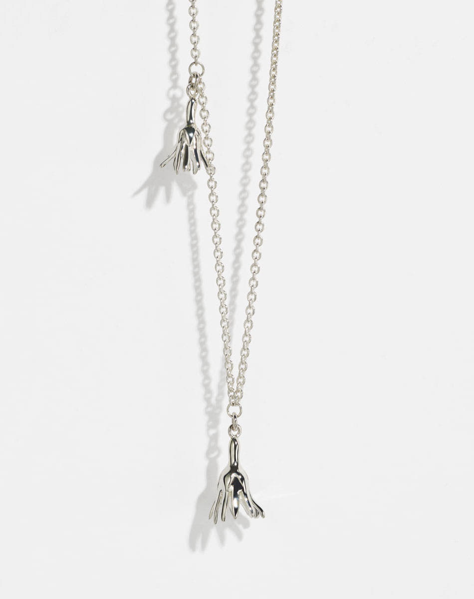 Meadowlark Jewellery’s Magda Two Charm Necklace in Sterling Silver. Two delicate, bell-shaped flower charms suspended from a fine diamond curb chain. A minimalist ode to blooming and the enduring cycles of life. From the Dreams collection.