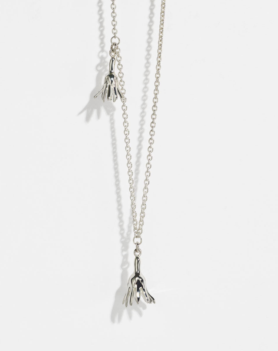 Meadowlark Jewellery’s Magda Two Charm Necklace in Sterling Silver. Two delicate, bell-shaped flower charms suspended from a fine diamond curb chain. A minimalist ode to blooming and the enduring cycles of life. From the Dreams collection.