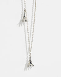Meadowlark Jewellery’s Magda Two Charm Necklace in Sterling Silver. Two delicate, bell-shaped flower charms suspended from a fine diamond curb chain. A minimalist ode to blooming and the enduring cycles of life. From the Dreams collection.