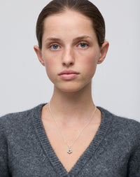 Meadowlark Jewellery’s floral Posie Charm Necklace in Sterling Silver, set with a single round brilliant cut African Garnet stone. Hung from a fine diamond curb chain. Inspired by classic floral motifs and our beloved Alba designs, a timeless symbol of grace, growth and renewal. Celebrating life’s continual renewal. From the Dreams collection.