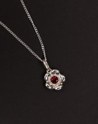 Meadowlark Jewellery’s floral Posie Charm Necklace in Sterling Silver, set with a single round brilliant cut African Garnet stone. Hung from a fine diamond curb chain. Inspired by classic floral motifs and our beloved Alba designs, a timeless symbol of grace, growth and renewal. Celebrating life’s continual renewal. From the Dreams collection.