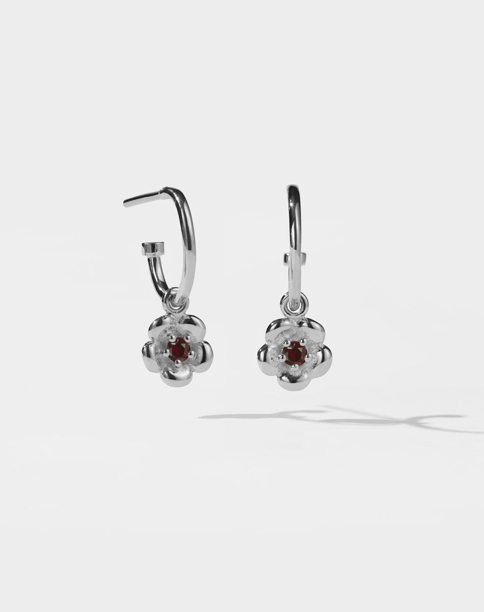 Meadowlark Jewellery’s floral Posie Signature Hoop Earrings in Sterling Silver, set with a single round brilliant cut African Garnet stone. Hung from classic signature hoop earrings. Inspired by classic floral motifs and our beloved Alba designs, a timeless symbol of grace, growth and renewal. Celebrating life’s continual renewal. From the Dreams collection.