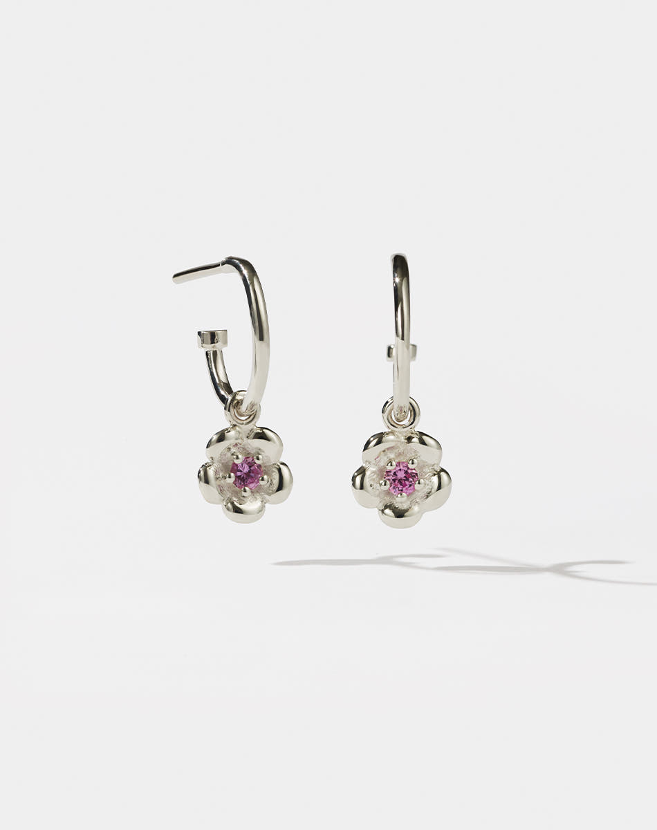 Meadowlark Jewellery’s floral Posie Signature Hoop Earrings in  Sterling Silver, set with a single round brilliant cut Pink Sapphire stone. Hung from classic signature hoop earrings. Inspired by classic floral motifs and our beloved Alba designs, a timeless symbol of grace, growth and renewal. Celebrating life’s continual renewal. From the Dreams collection.