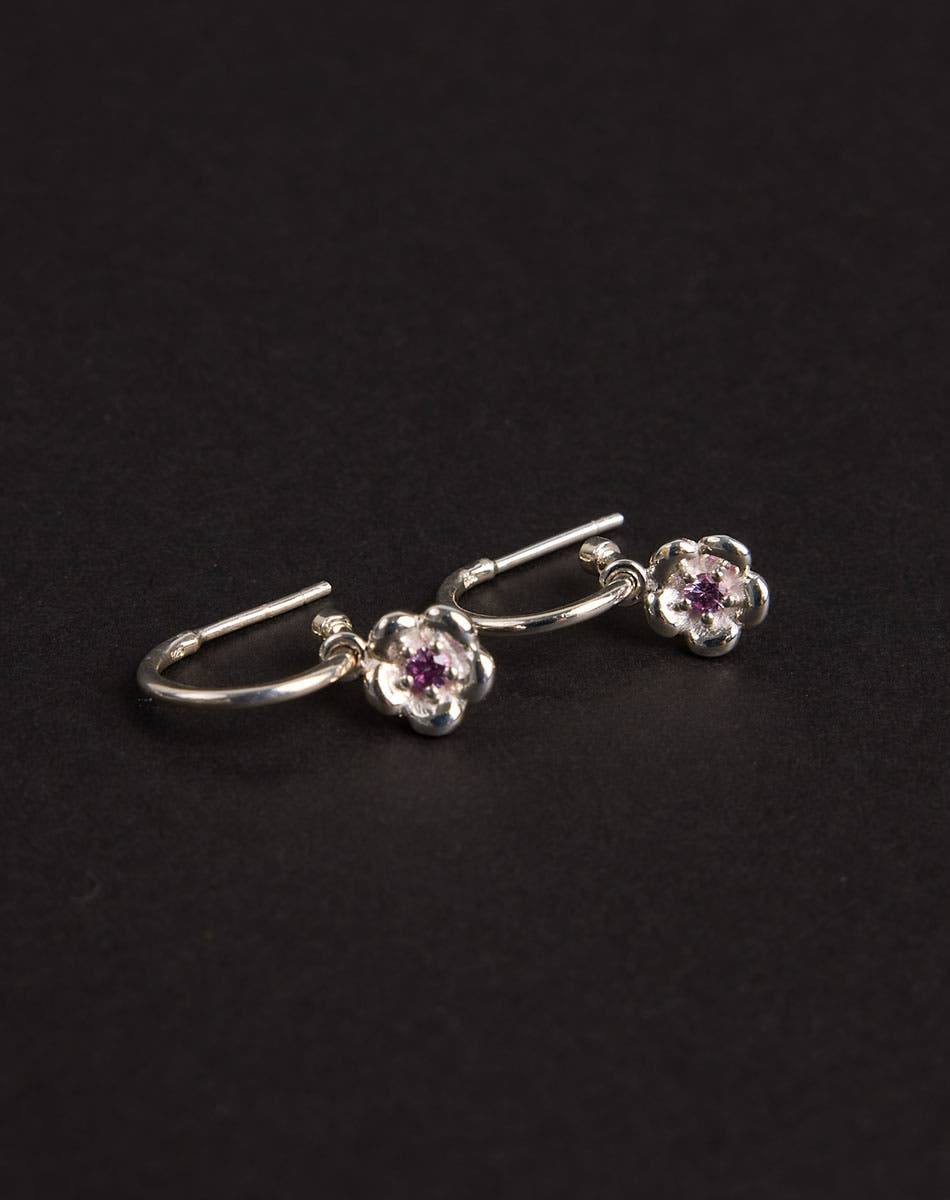 Meadowlark Jewellery’s floral Posie Signature Hoop Earrings in  Sterling Silver, set with a single round brilliant cut Pink Sapphire stone. Hung from classic signature hoop earrings. Inspired by classic floral motifs and our beloved Alba designs, a timeless symbol of grace, growth and renewal. Celebrating life’s continual renewal. From the Dreams collection.